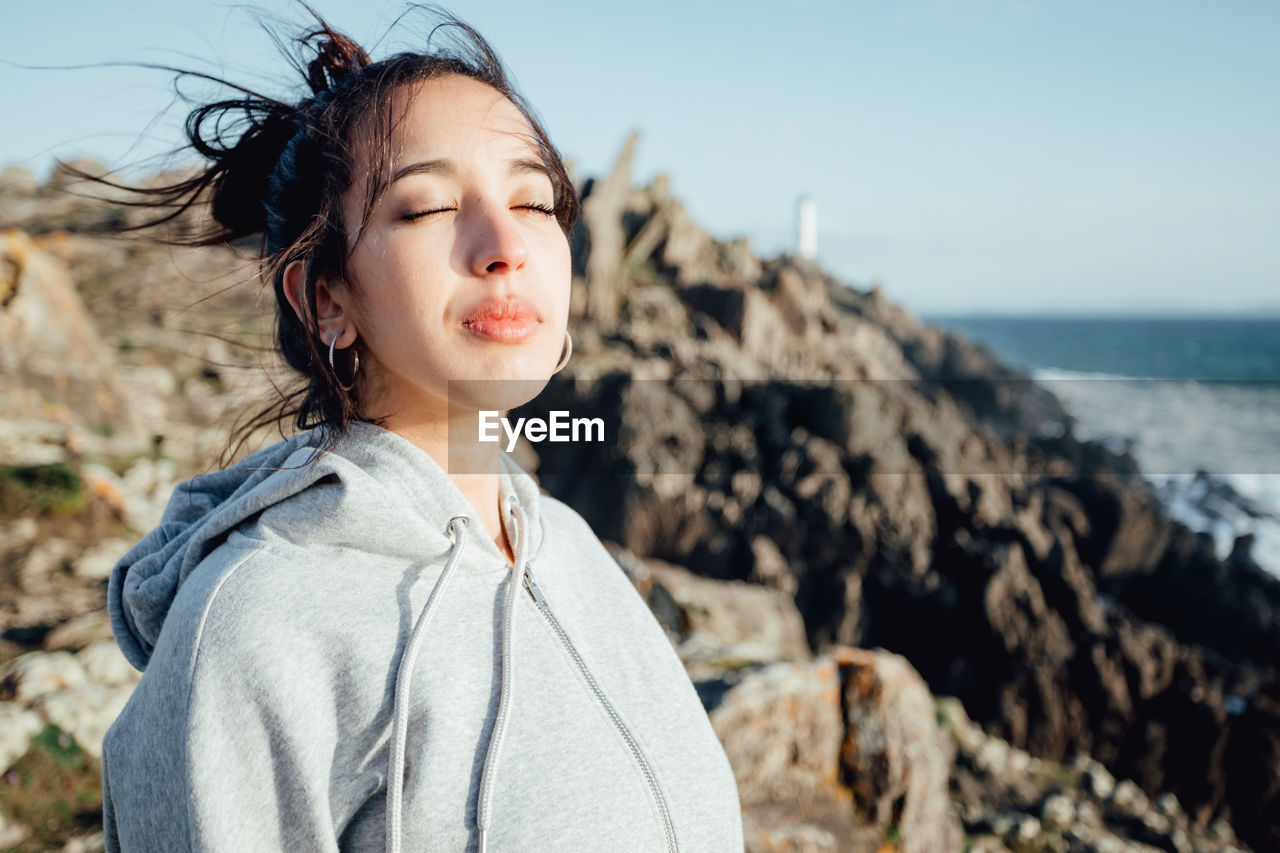 Portrait of young woman looking away at beach