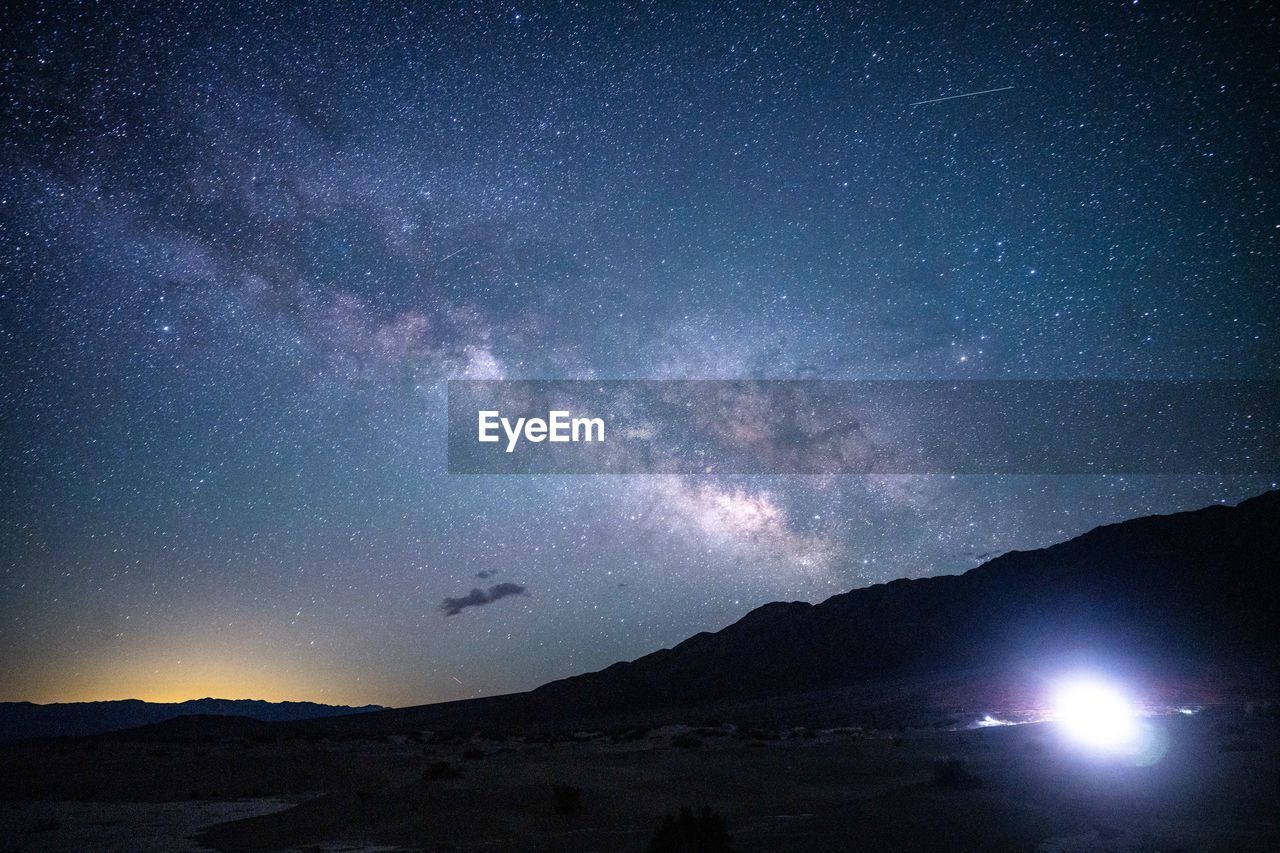 low angle view of silhouette mountains against sky at night