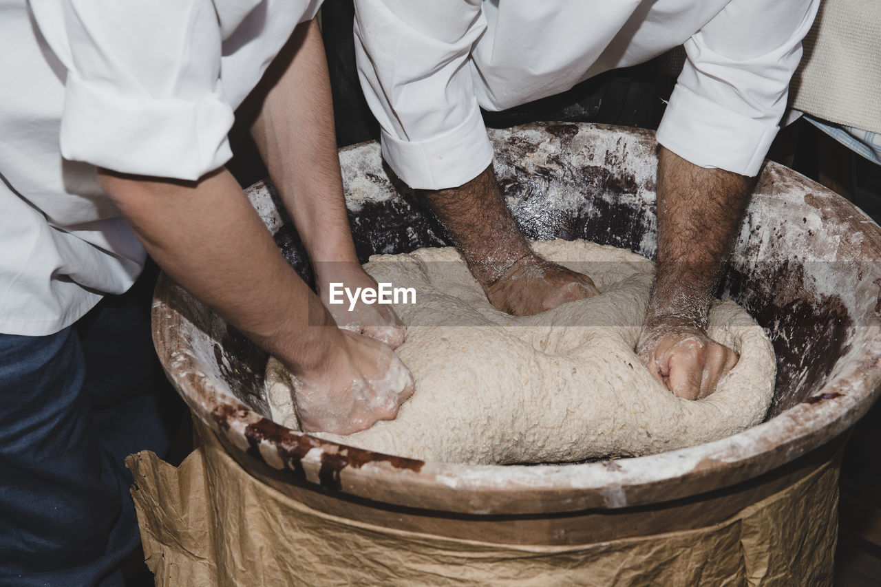 HIGH ANGLE VIEW OF PEOPLE WORKING ON CUTTING BOARD