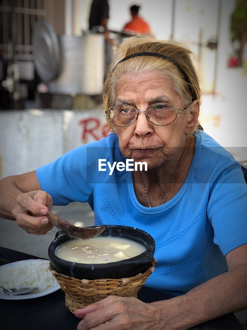 Senior woman having soup while sitting at table