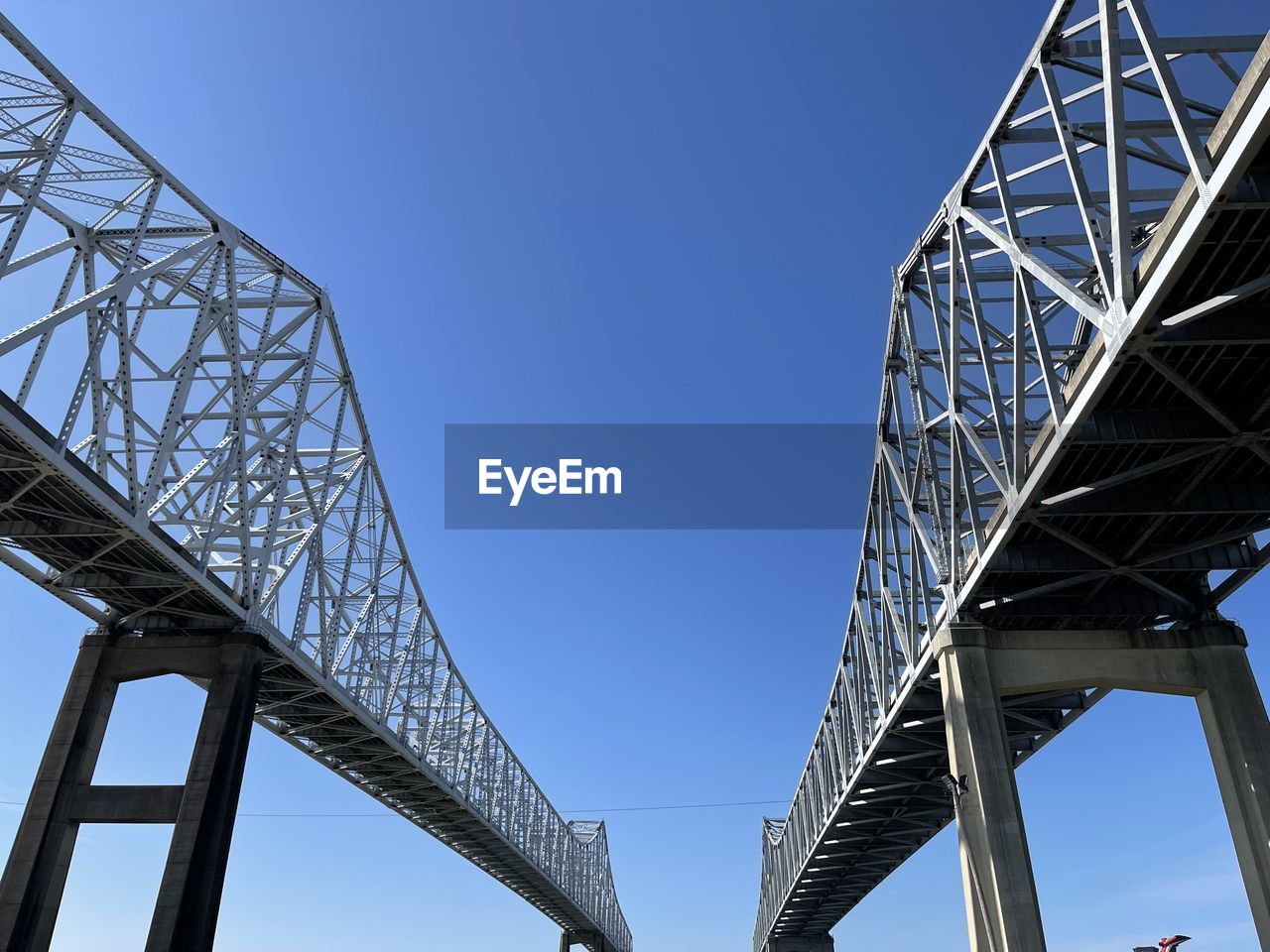 architecture, bridge, built structure, sky, transportation, landmark, cable-stayed bridge, nature, city, blue, engineering, clear sky, metal, low angle view, travel destinations, outdoors, cantilever bridge, alloy, steel, girder, travel, overpass, day, business finance and industry, water, tourism