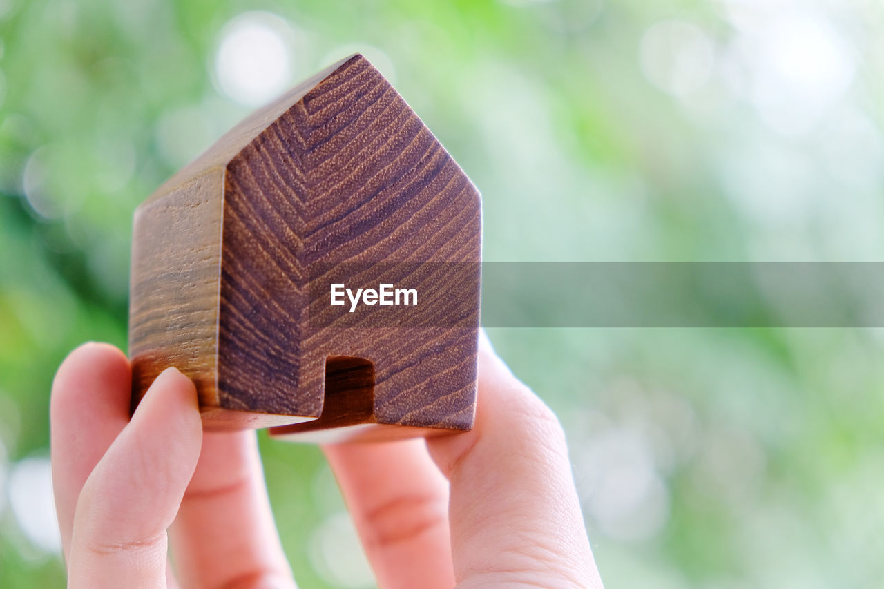 Cropped hand holding wooden model home