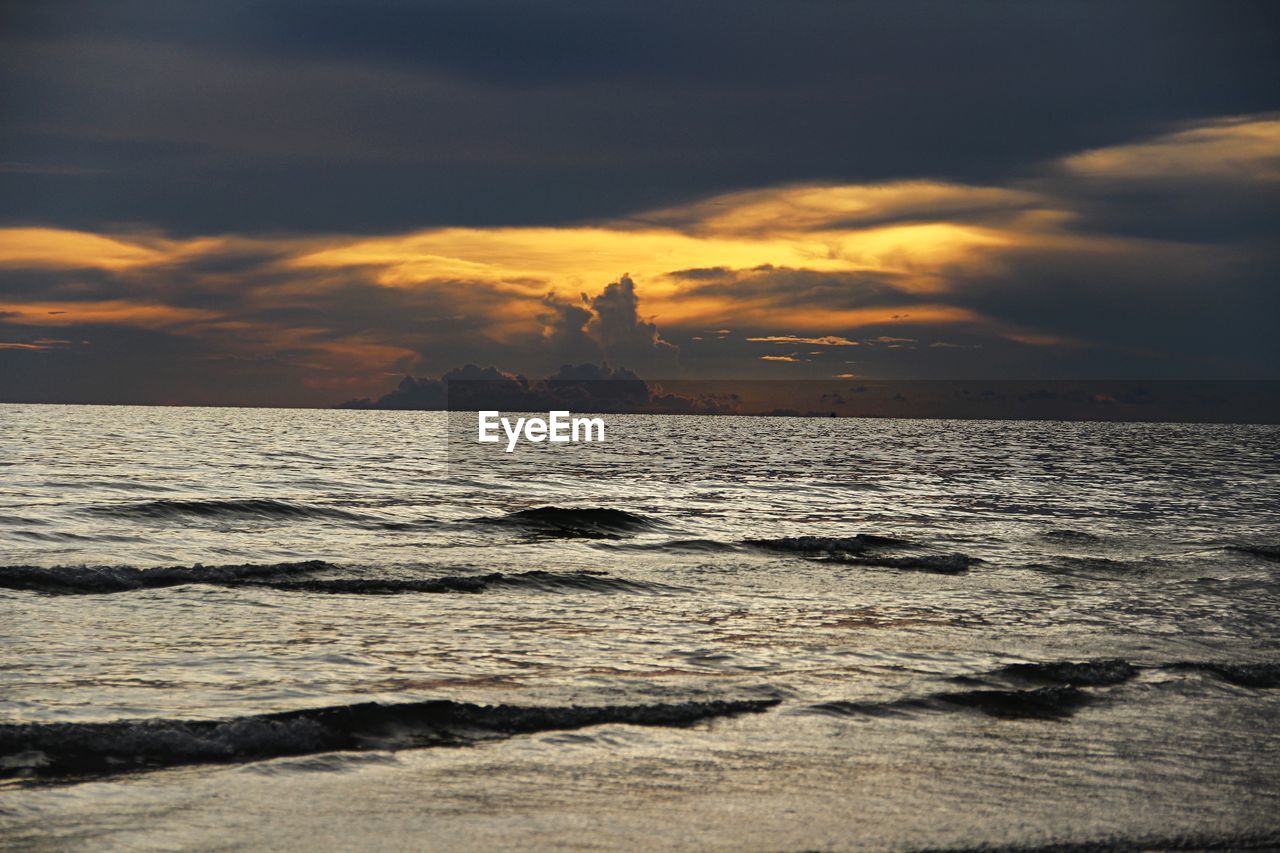 SCENIC VIEW OF BEACH AGAINST SKY DURING SUNSET