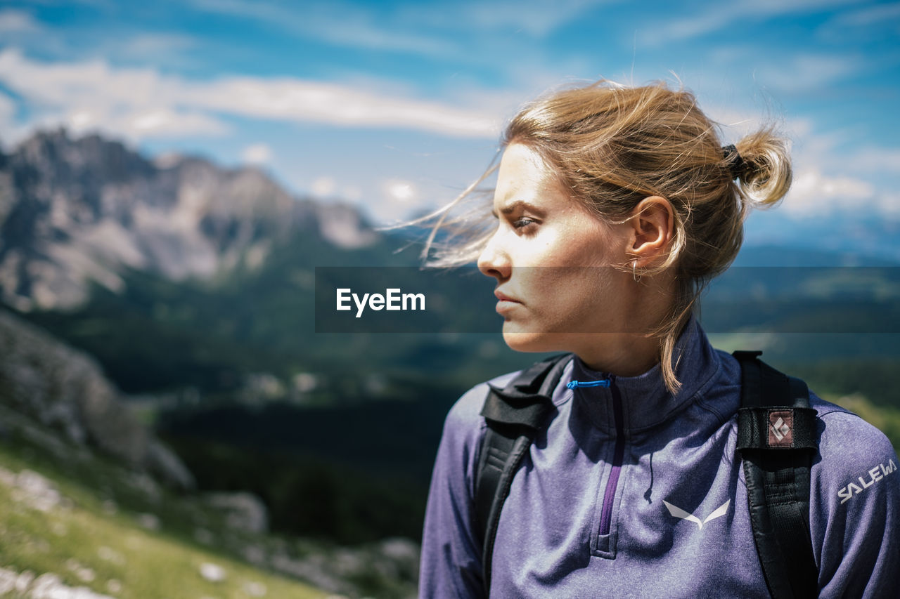 Close-up of young woman looking away against sky