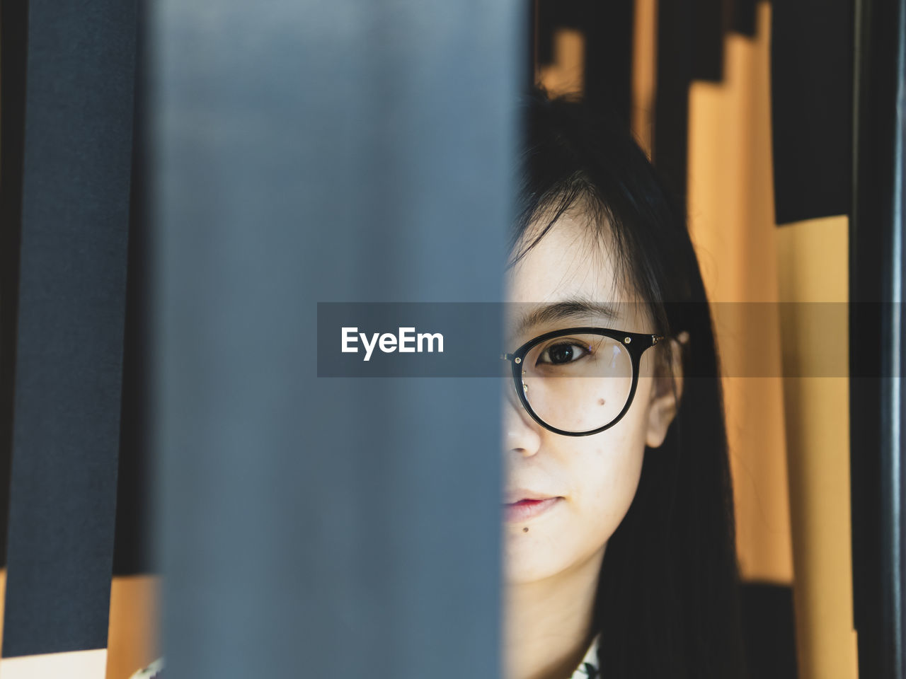 Portrait of young woman looking by wood