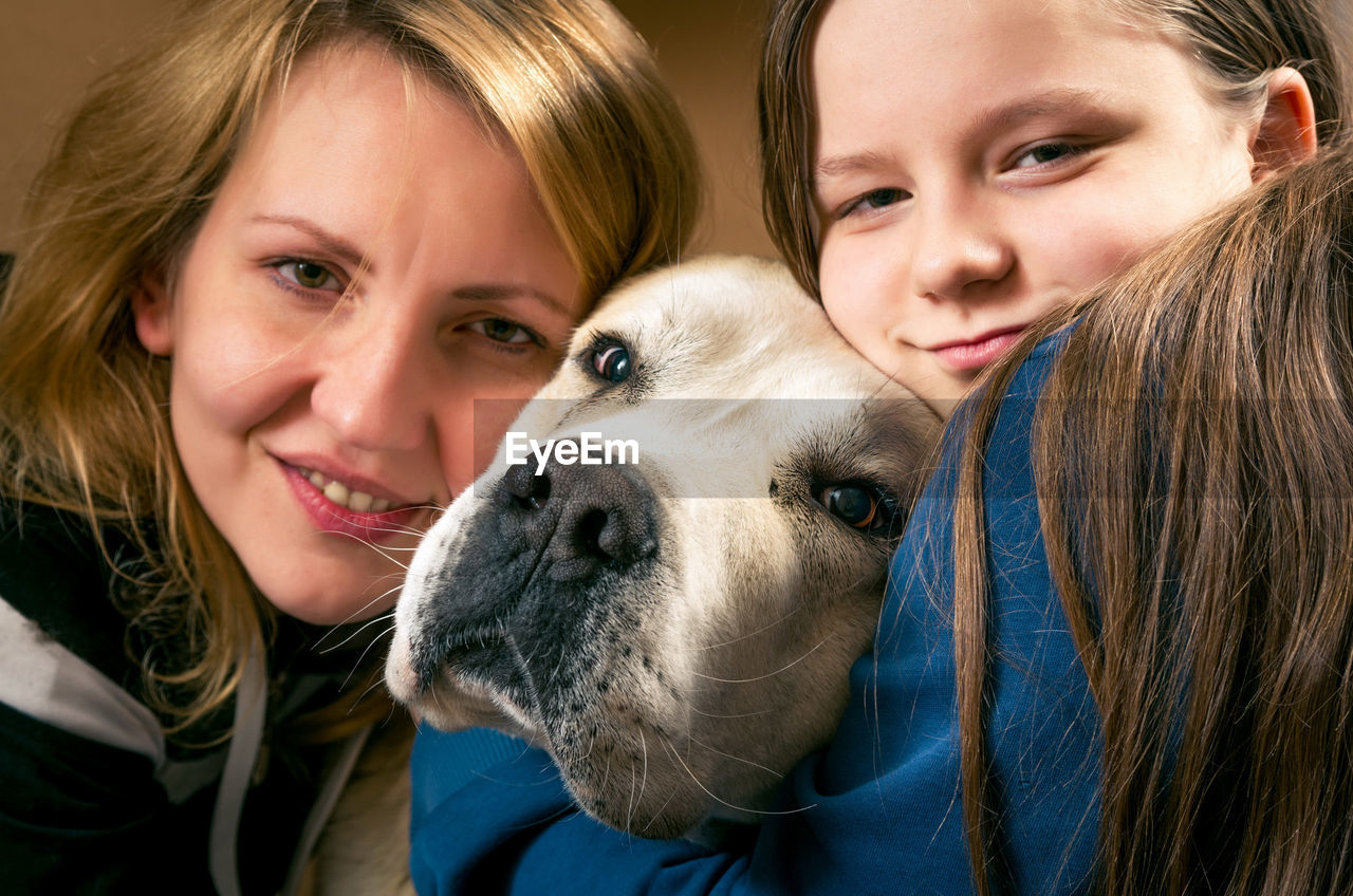 Portrait of mother and daughter with dog