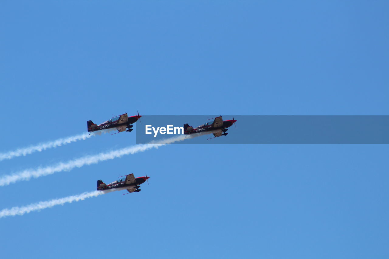 LOW ANGLE VIEW OF AIRSHOW AGAINST SKY