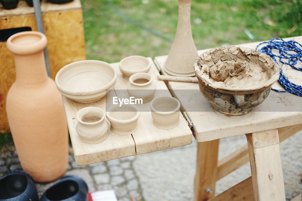 High angle view of clay bowls and containers on table