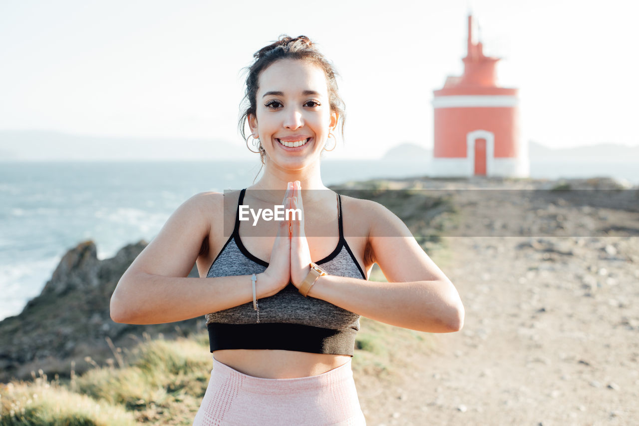 Portrait of young woman standing at beach