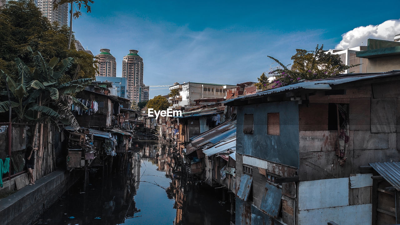 Canal amidst buildings against sky