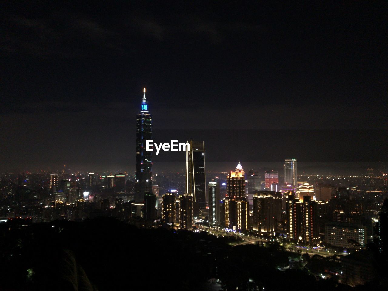 Illuminated buildings against sky at night