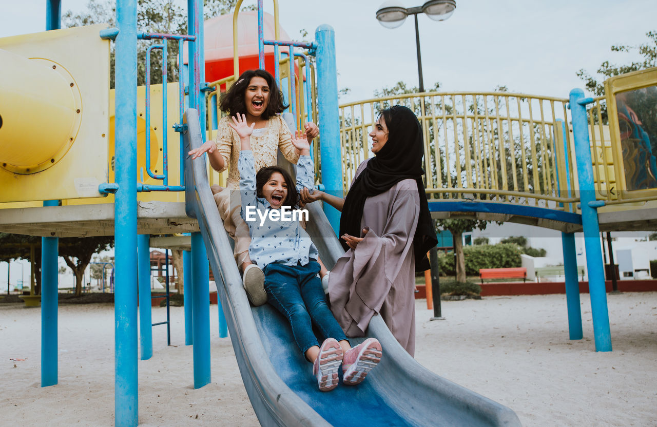 Mother with cheerful daughters enjoying at park