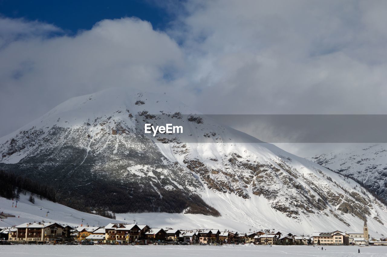 GROUP OF PEOPLE ON SNOWCAPPED MOUNTAIN AGAINST SKY