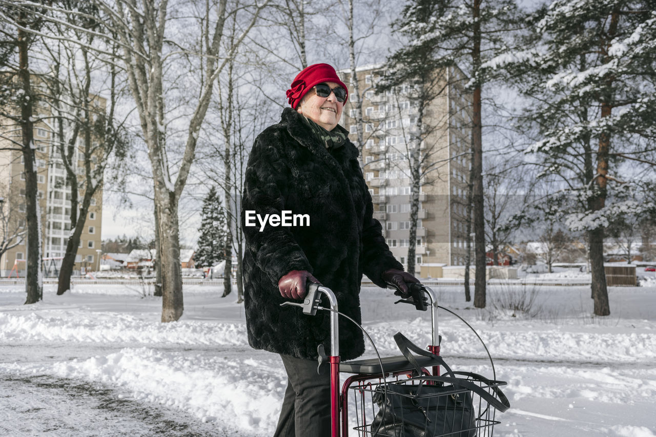 Senior woman with walking frame having walk at winter