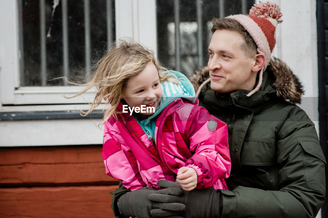 Candid portrait of father and daughter sitting playing outside