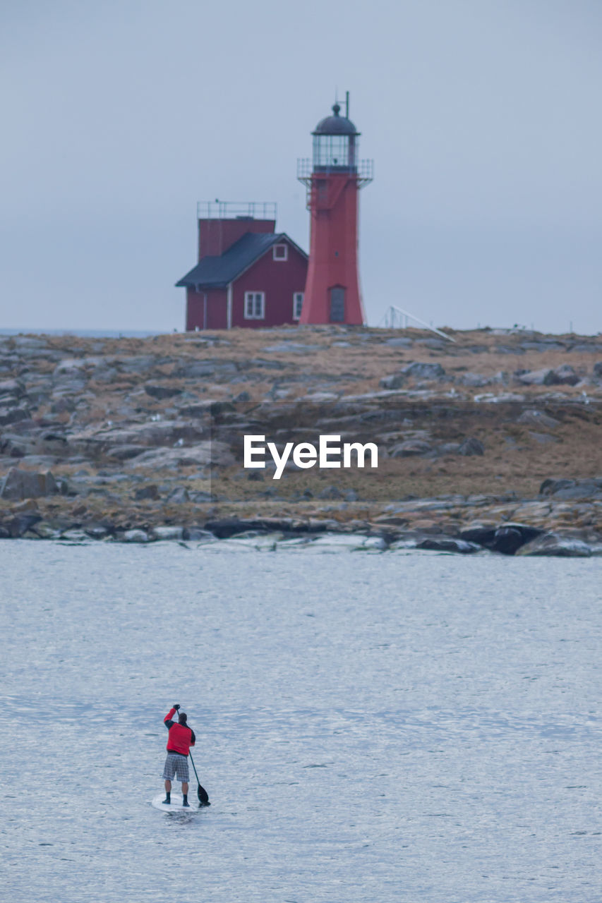 View of red lighthouse against cloudy sky