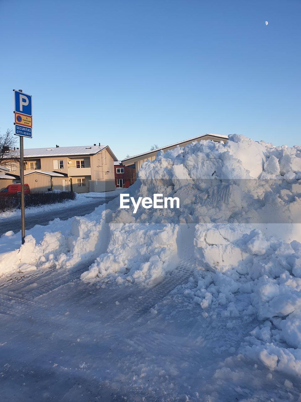 SNOW COVERED HOUSES BY BUILDING AGAINST SKY