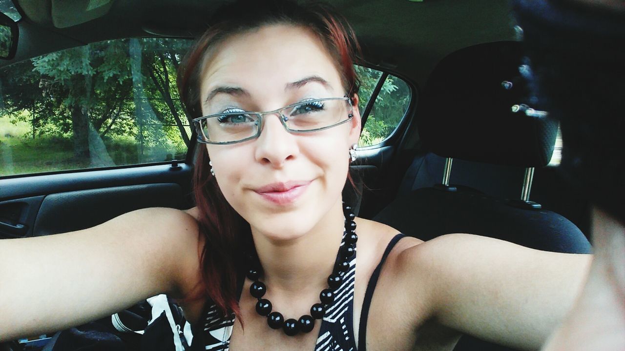 Portrait of young woman wearing eyeglasses in car