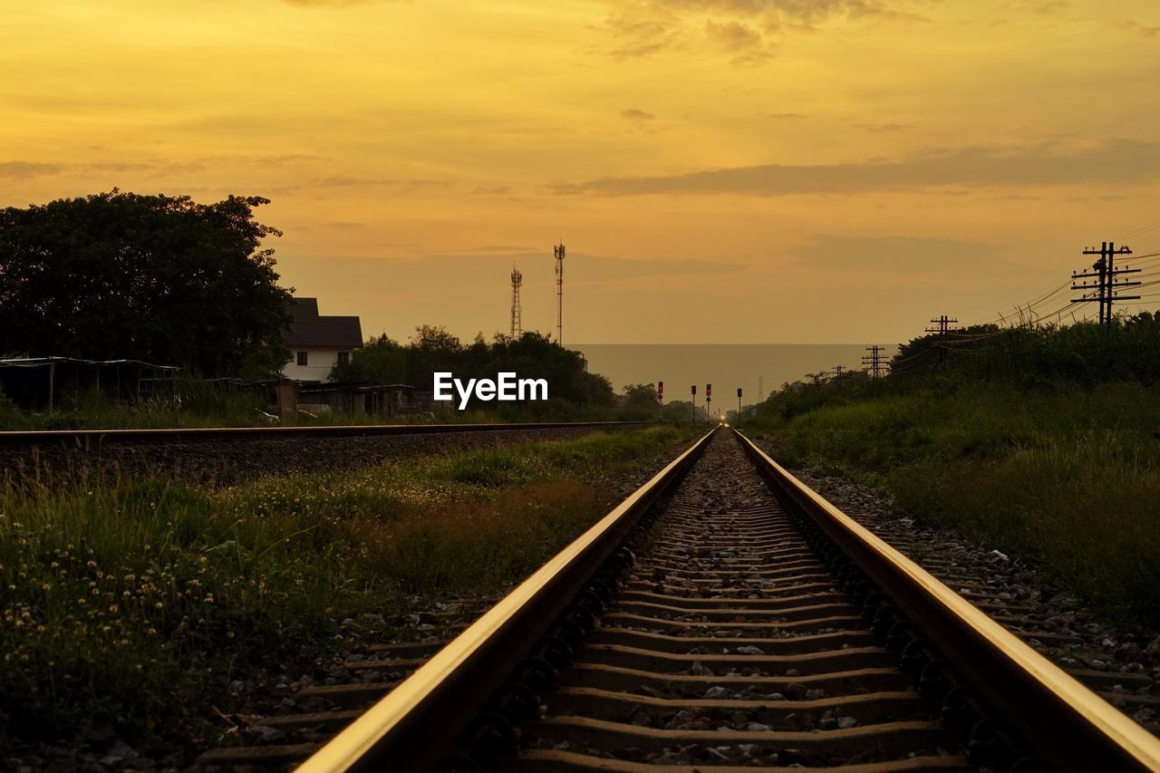 RAILROAD TRACK AGAINST SKY DURING SUNSET