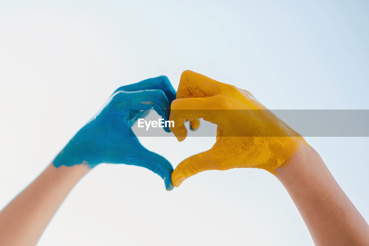 Love ukraine concept. hands in heart form painted in ukraine flag color - yellow and blue.