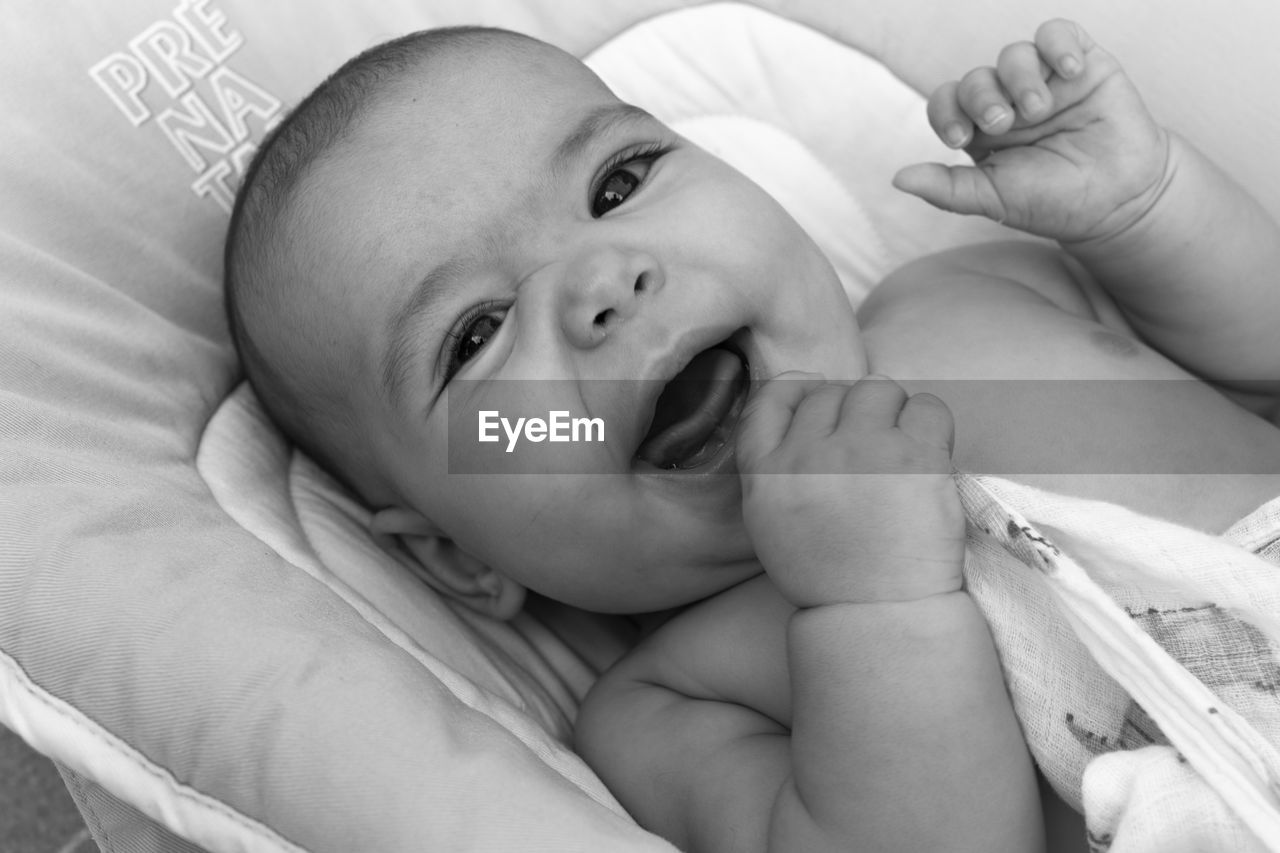 PORTRAIT OF CUTE BABY GIRL LYING ON BED