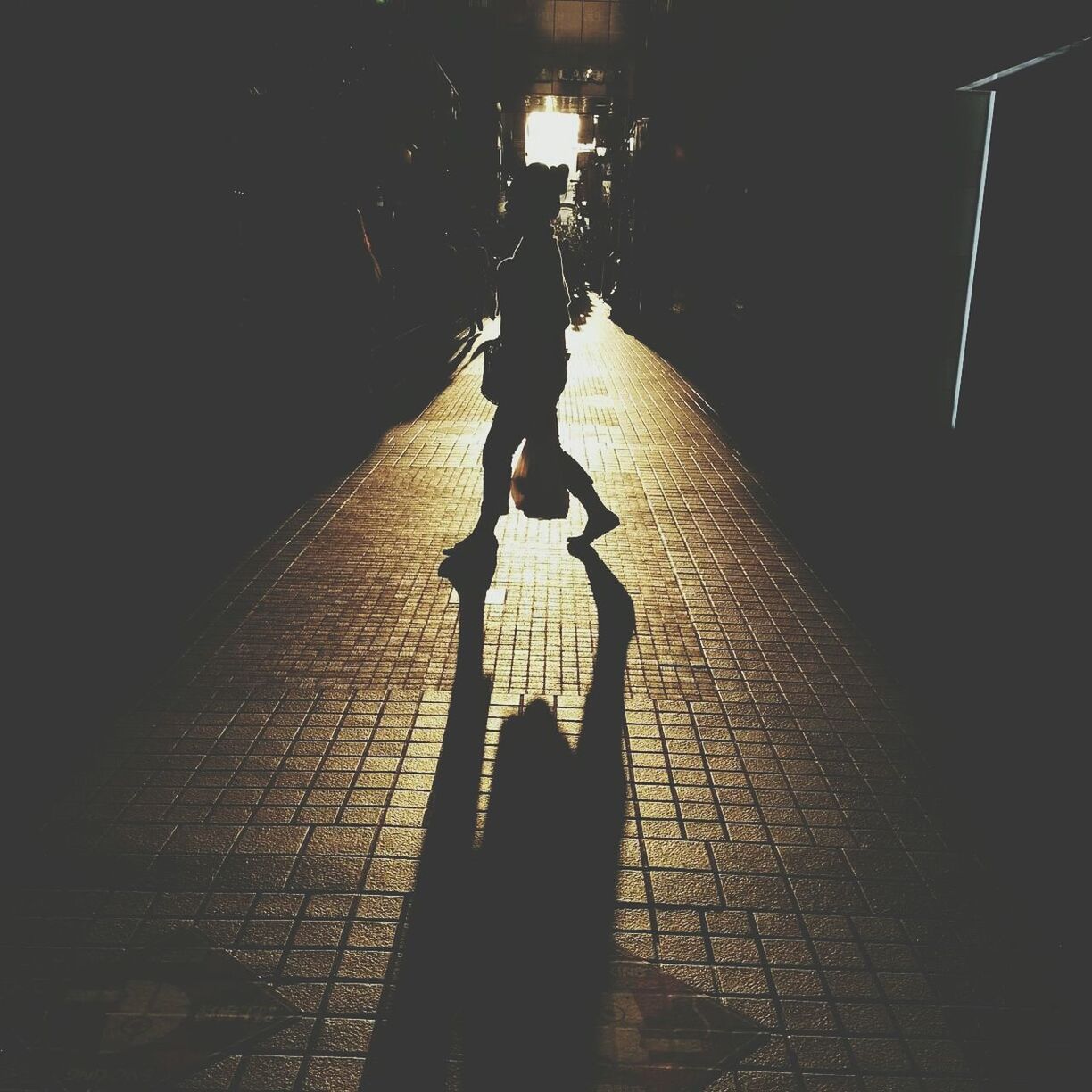 Silhouette woman walking on footpath