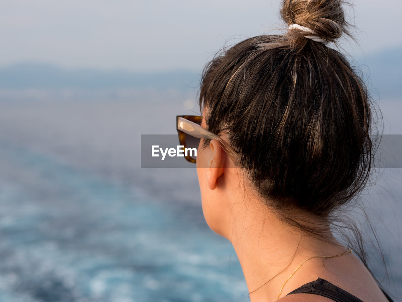 Close-up of woman looking at sea against clear sky