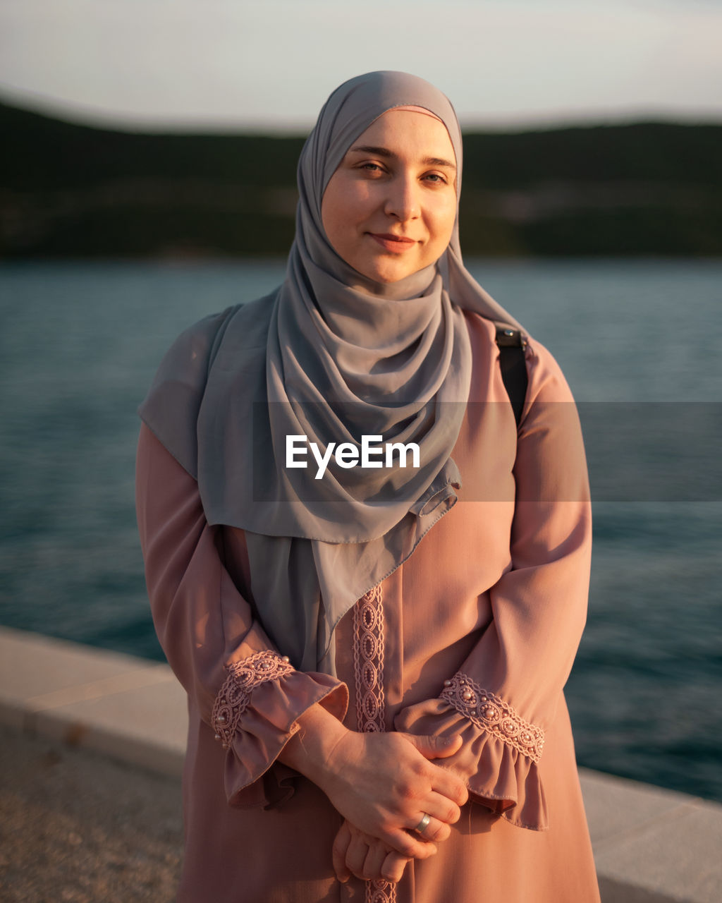 Portrait of young woman standing at beach