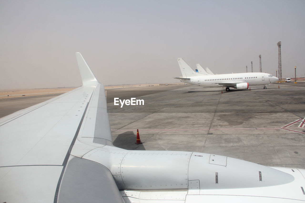 Airplane on airport runway against sky