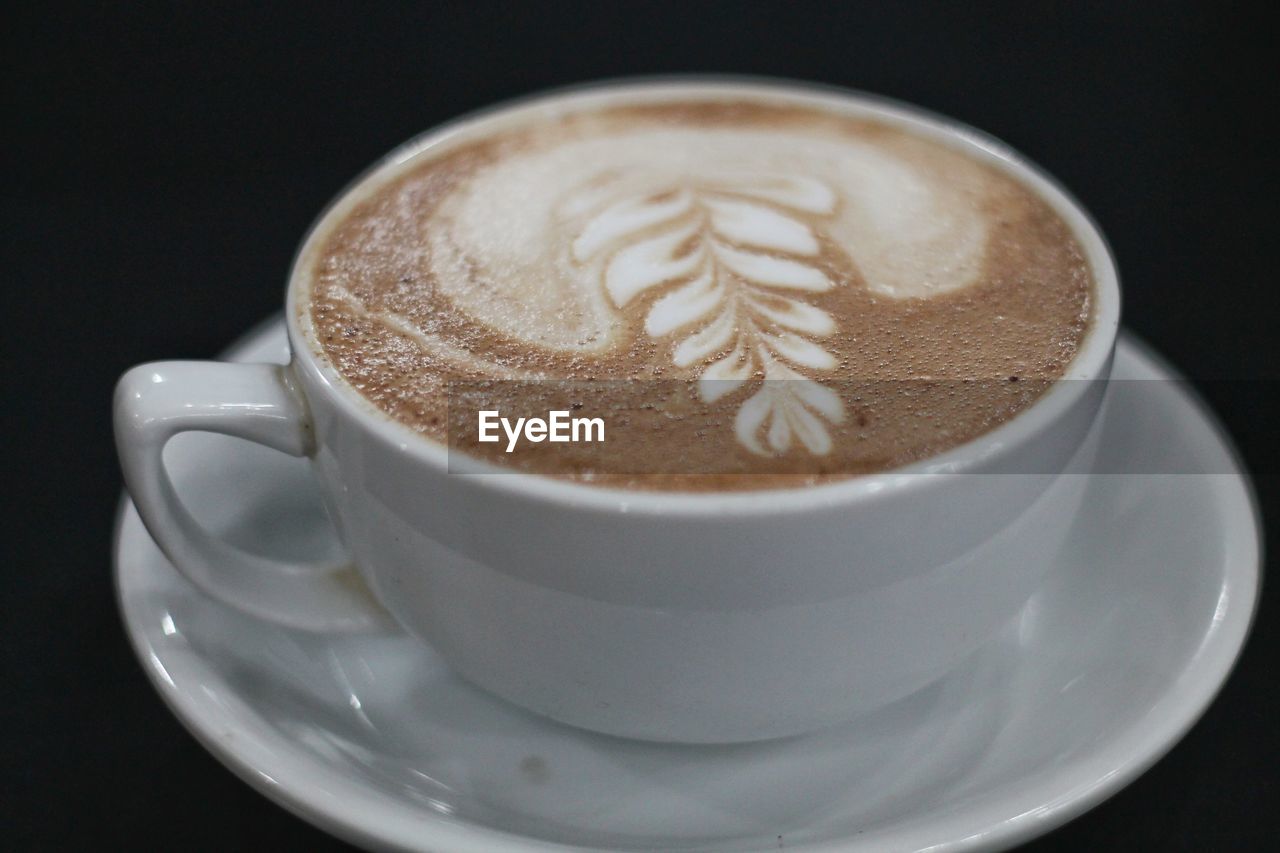 CLOSE-UP OF CAPPUCCINO ON BLACK COFFEE