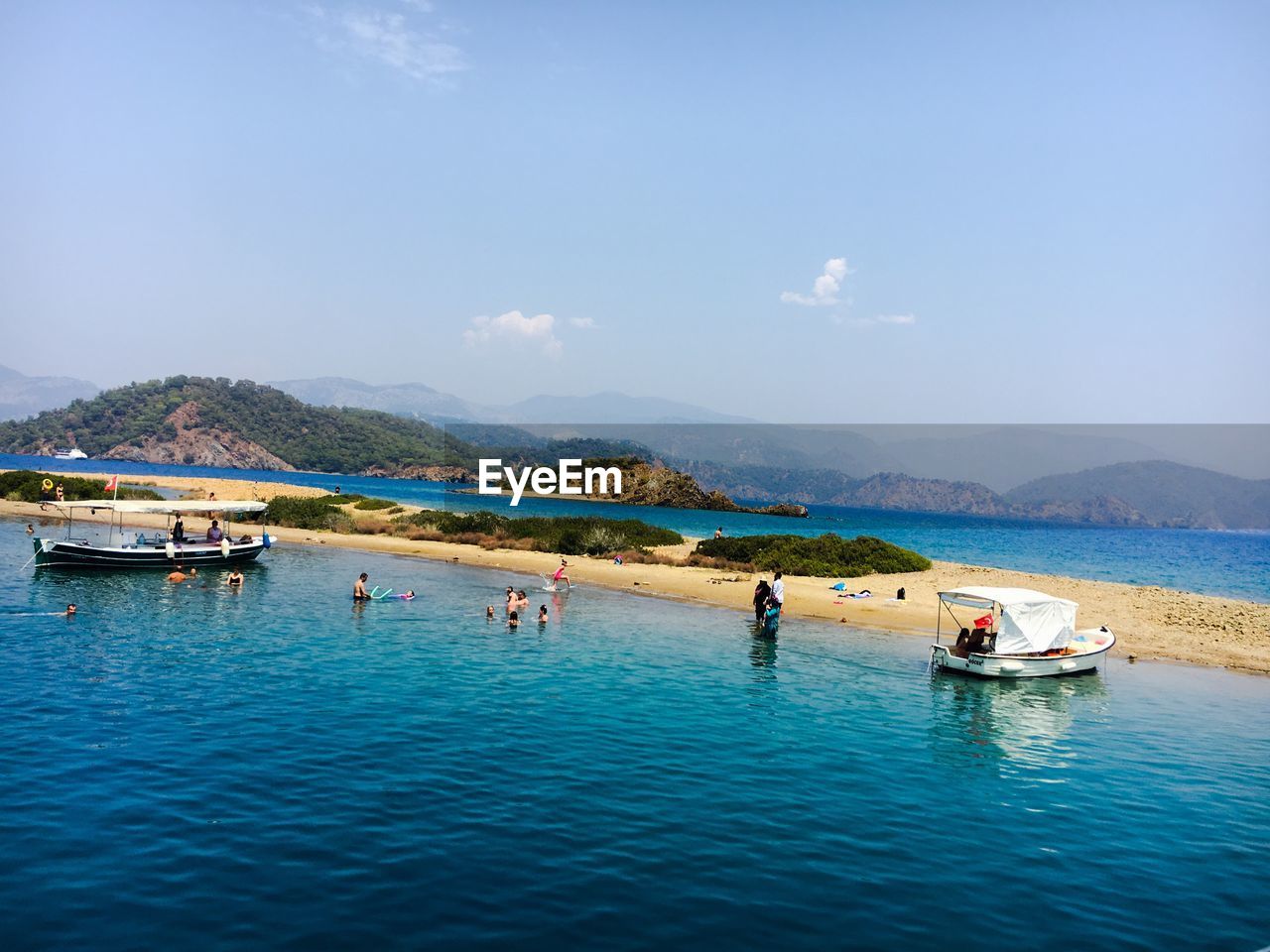 PEOPLE ON BOATS IN SEA AGAINST SKY