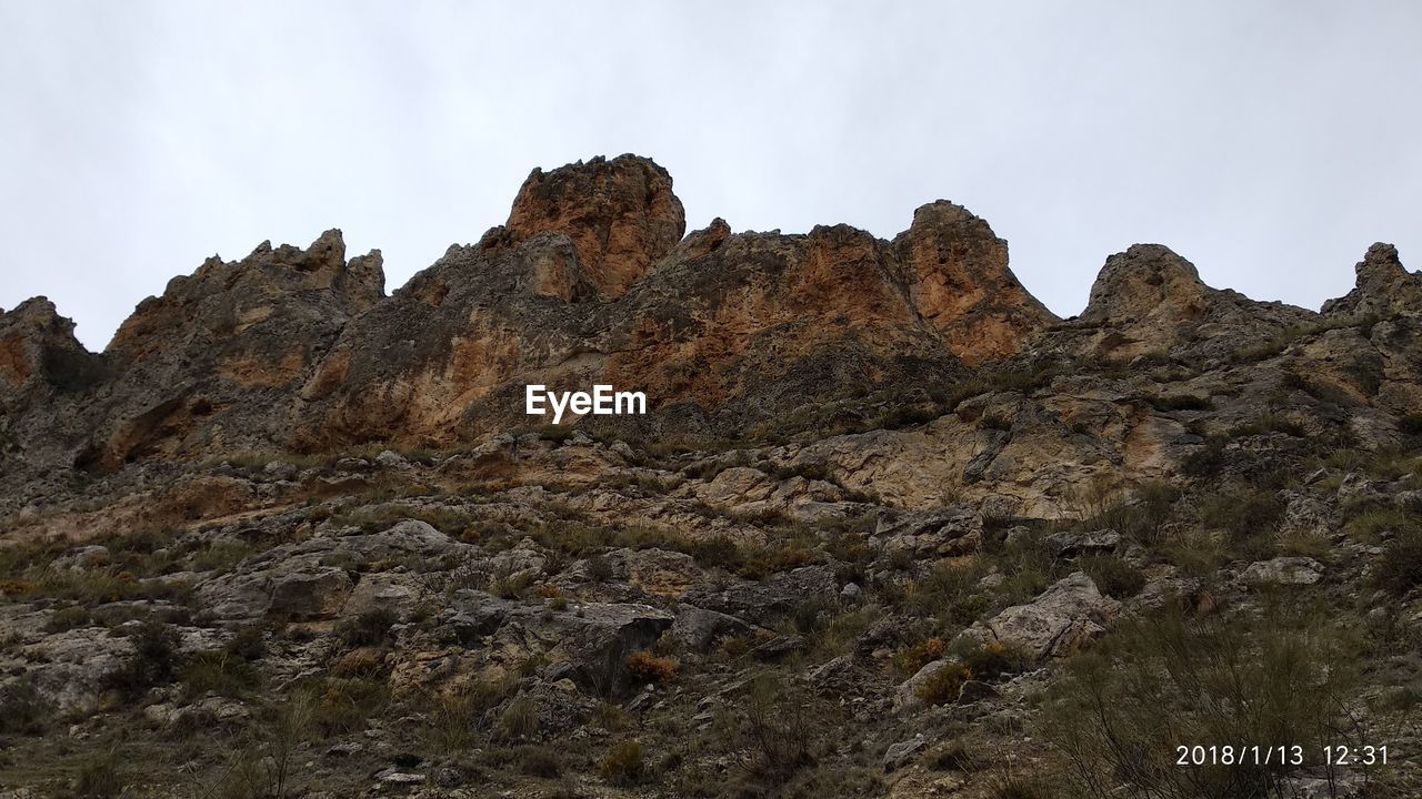 LOW ANGLE VIEW OF ROCK FORMATIONS AGAINST SKY