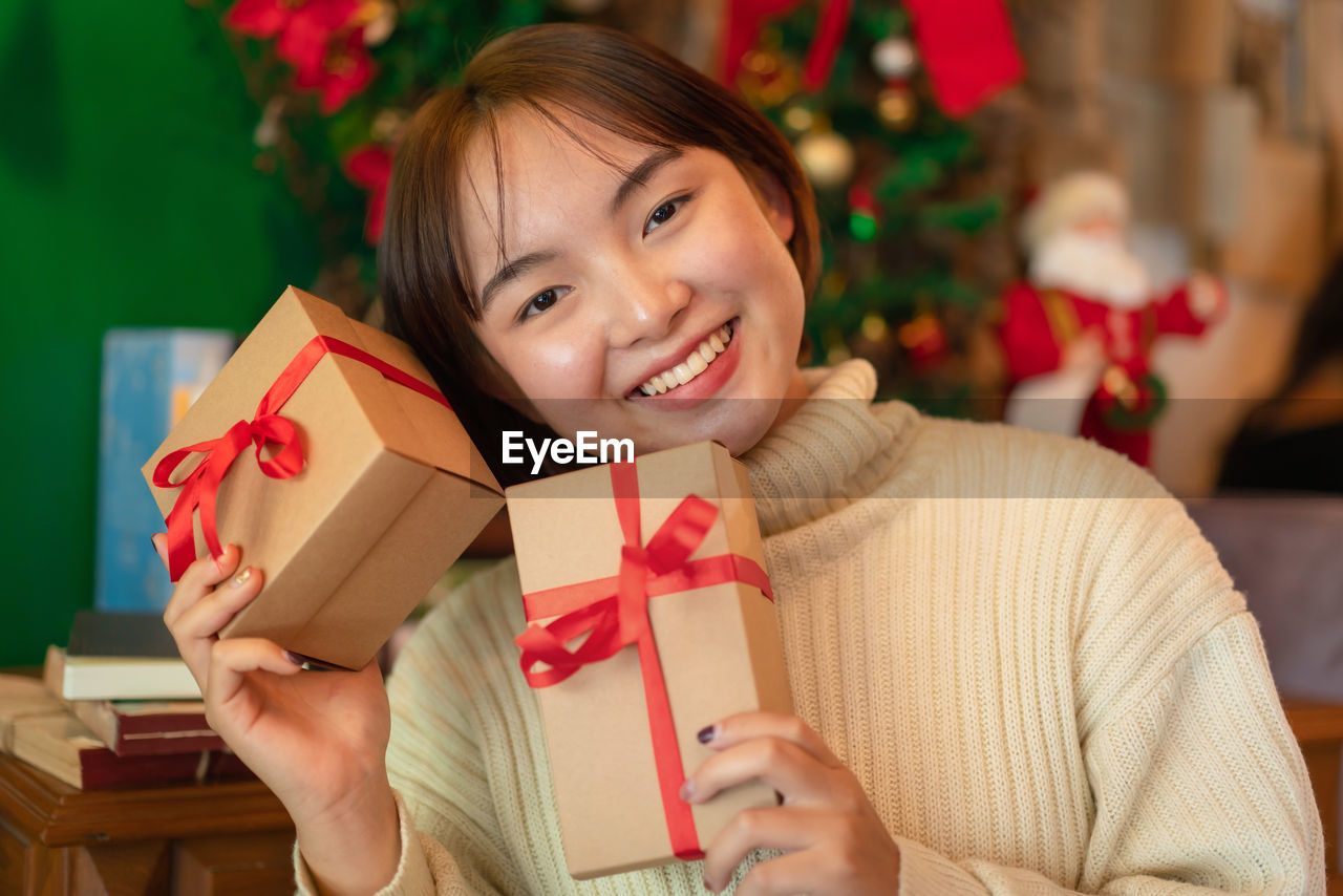 portrait of young woman opening gift