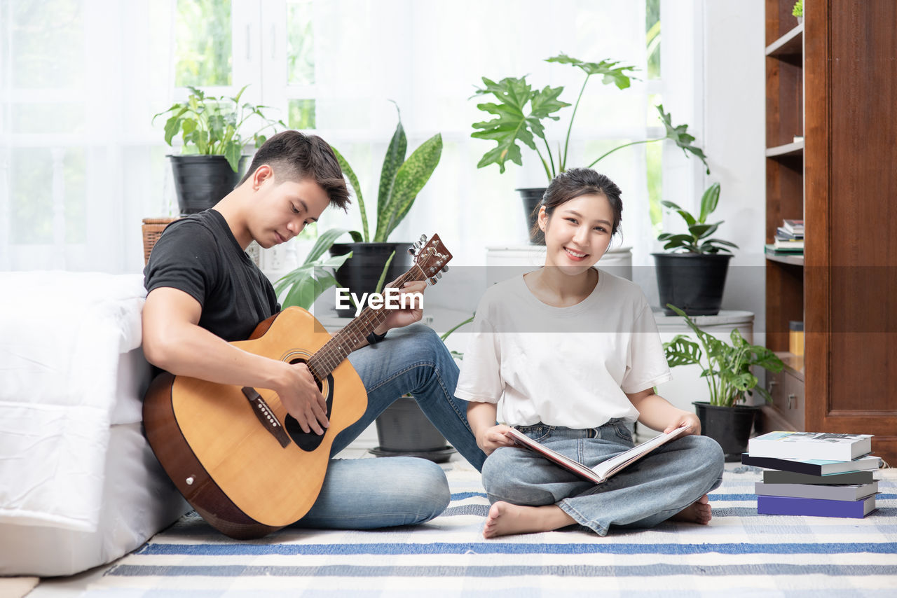 YOUNG MAN PLAYING GUITAR IN A ROOM