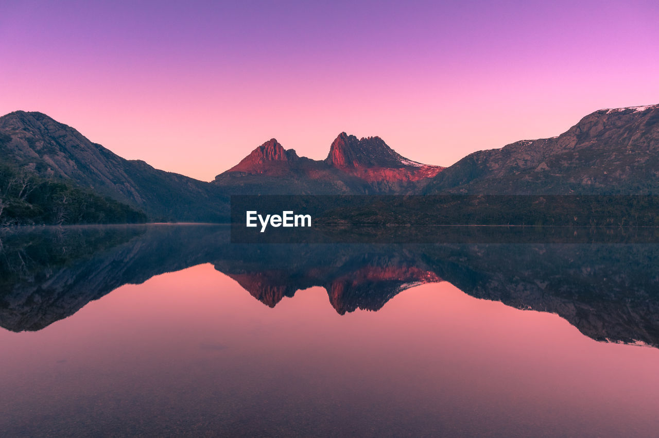Scenic view of lake against mountains during sunset