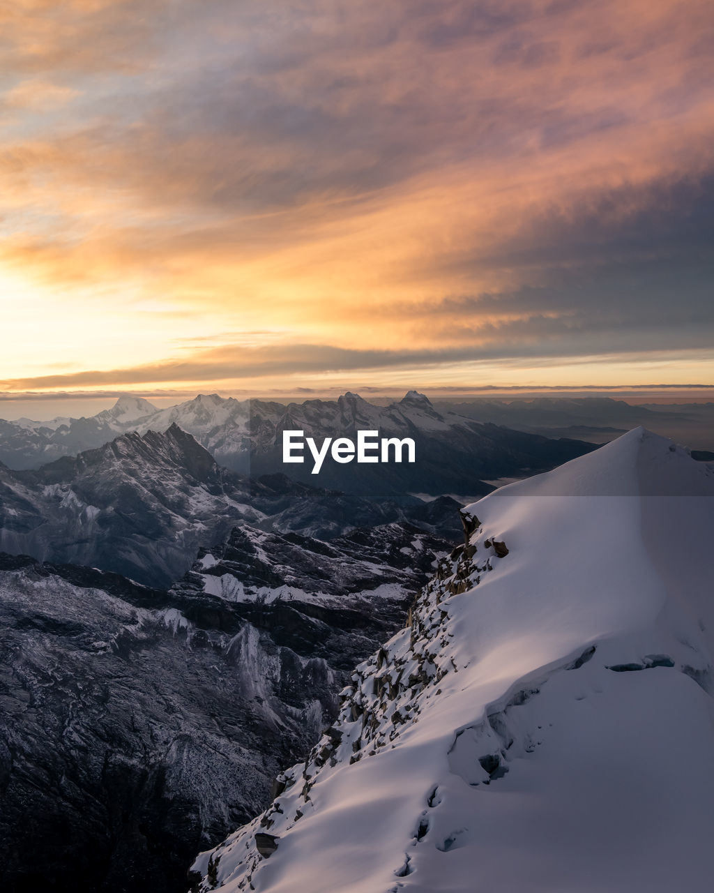 SNOW COVERED MOUNTAINS AGAINST SKY DURING SUNSET