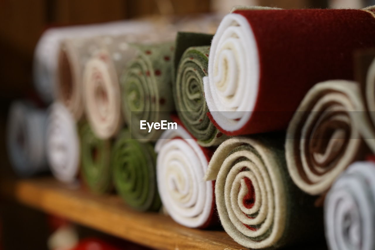 Close-up of rolled up fabrics on shelf