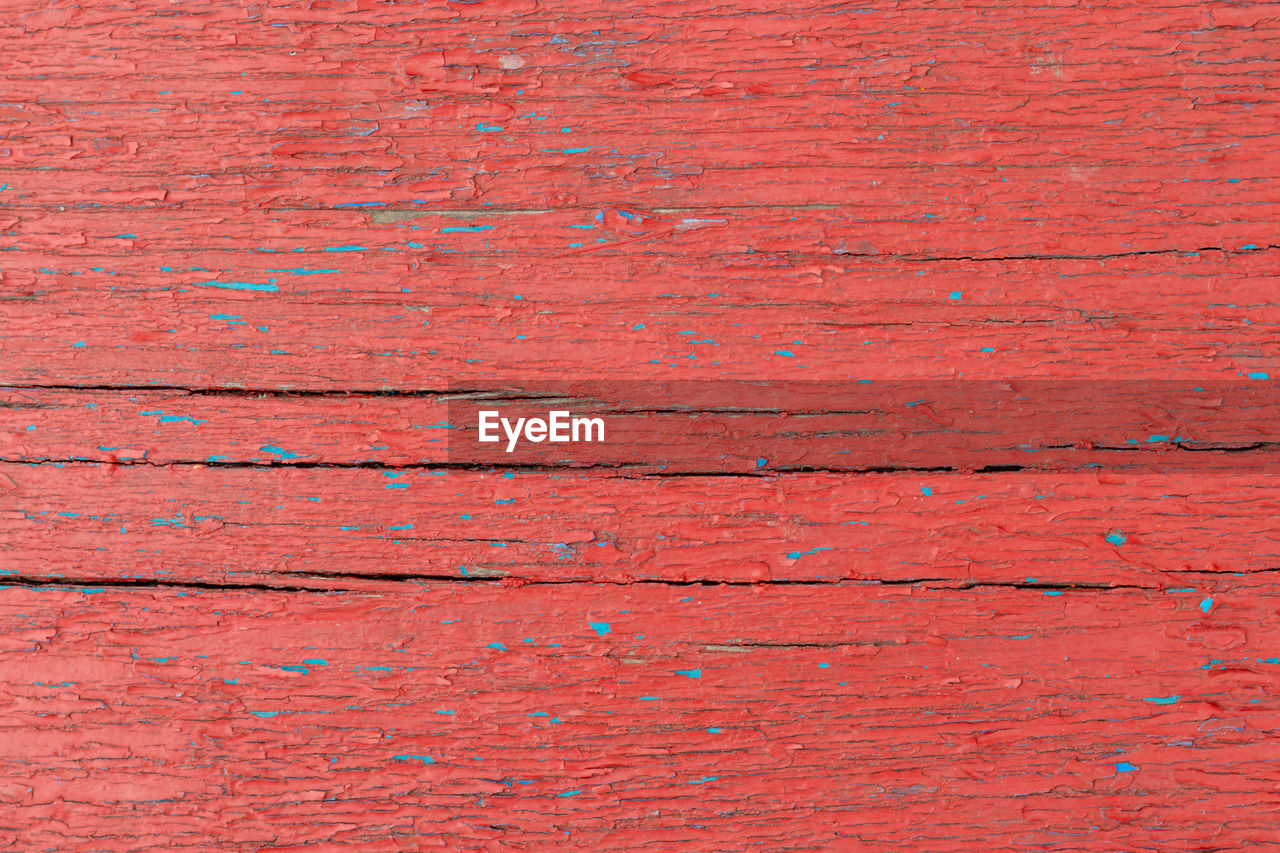 Red old wooden background with blue splashes with cracks. copy space. place for text. basis for