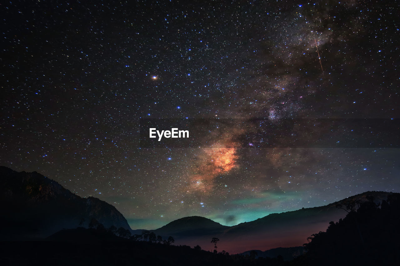 Silhouette mountains against sky at night