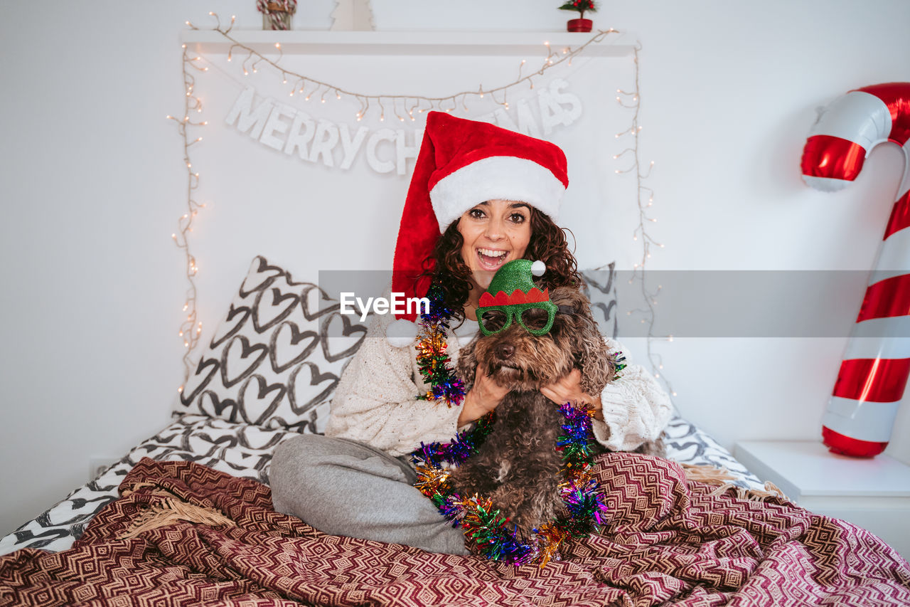 Portrait of woman with dog at home. christmas time 