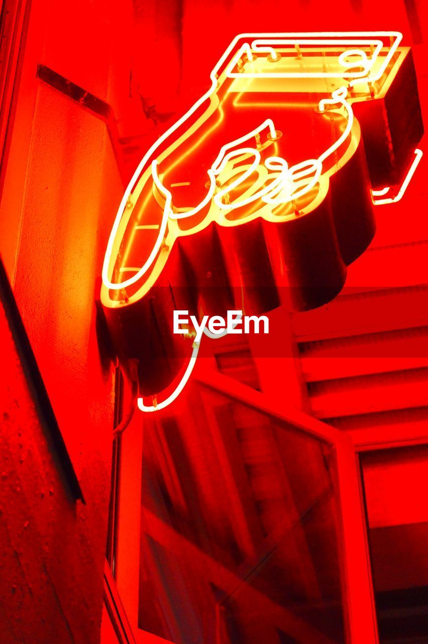 Low angle view of red neon sign in building