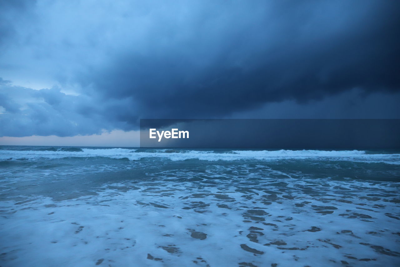 Scenic view of sea against storm clouds