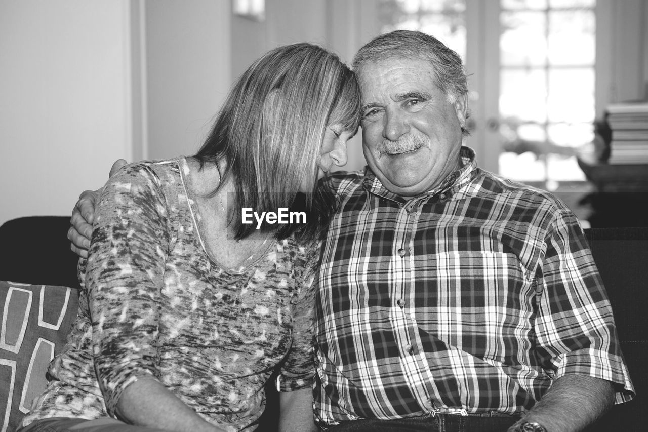 Portrait of happy couple sitting at home