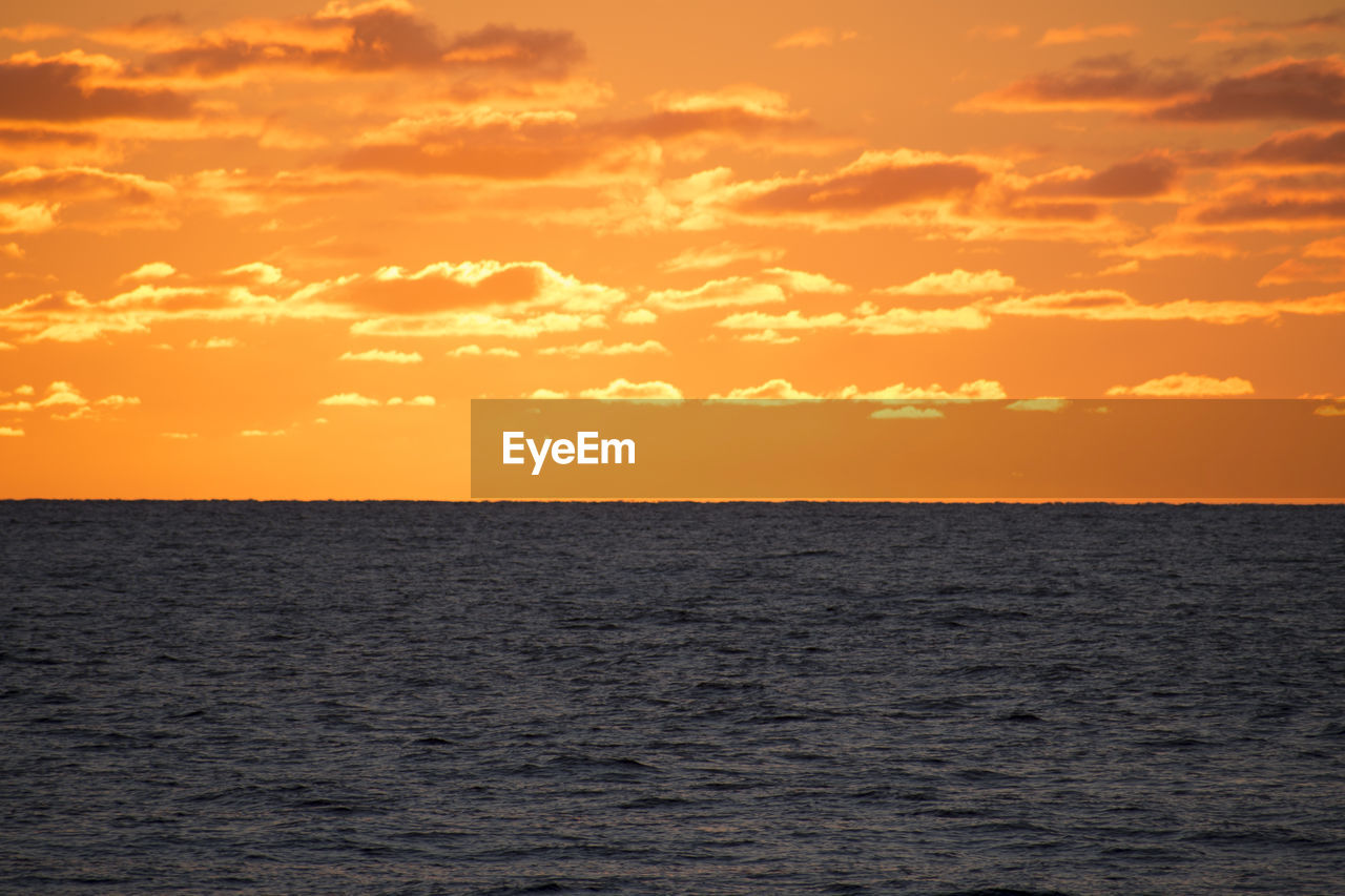 SCENIC VIEW OF SEA AGAINST ORANGE SKY DURING SUNSET