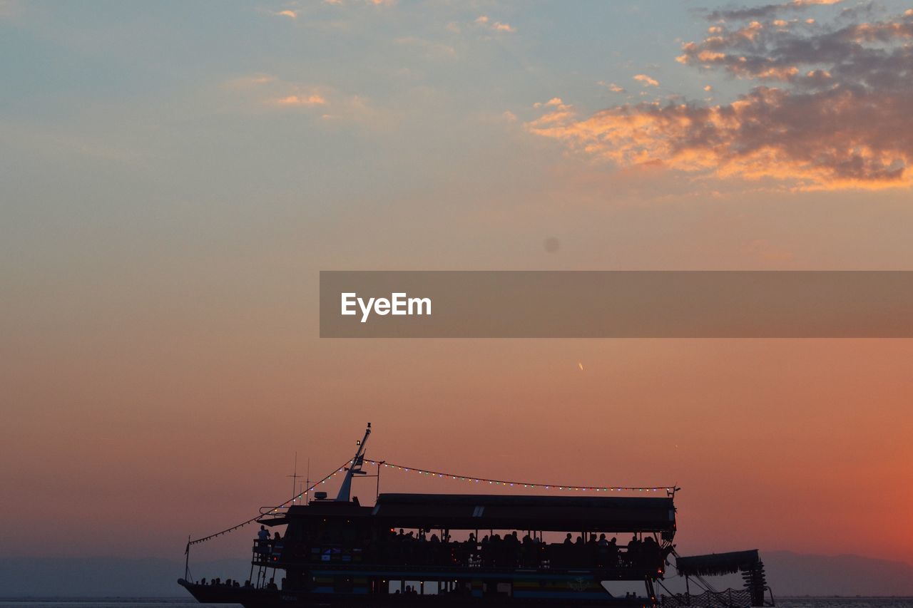 Silhouette boat in sea against sky during sunset
