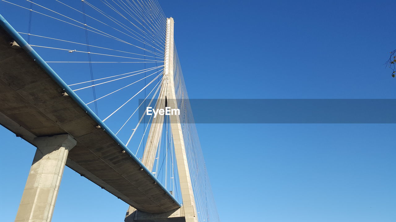 LOW ANGLE VIEW OF GOLDEN BRIDGE AGAINST CLEAR BLUE SKY