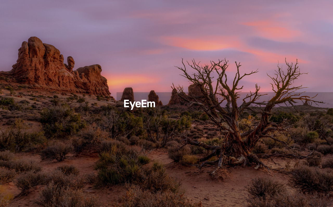 Rock formations on landscape against sky during sunset