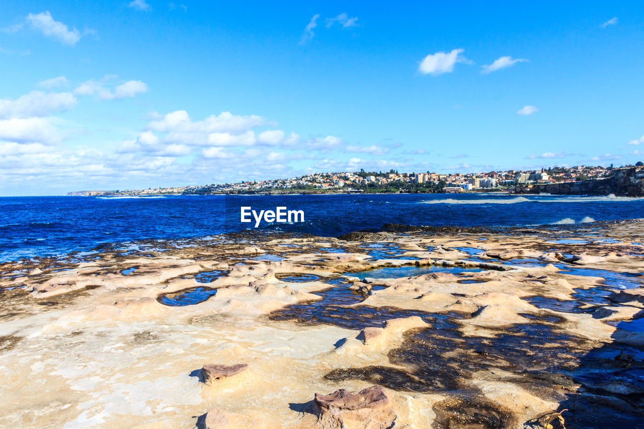 Scenic view of beach against blue sky