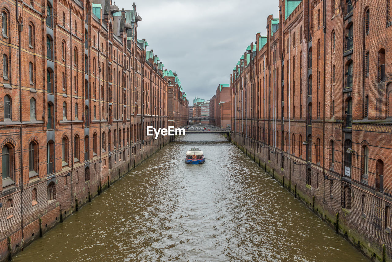 CANAL AMIDST BUILDINGS AGAINST SKY