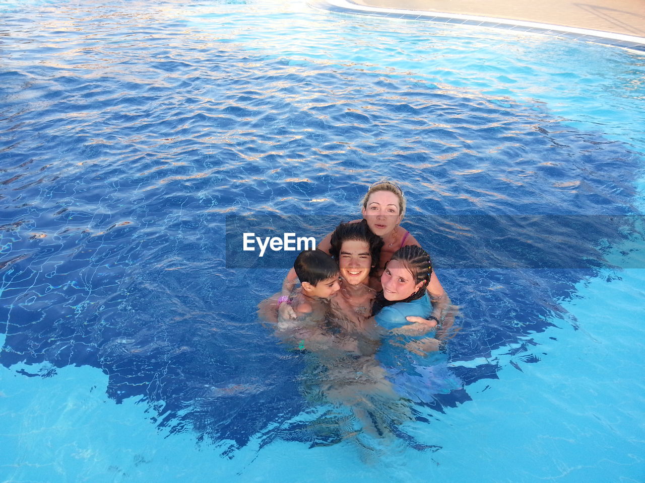 Portrait of happy family enjoying in swimming pool